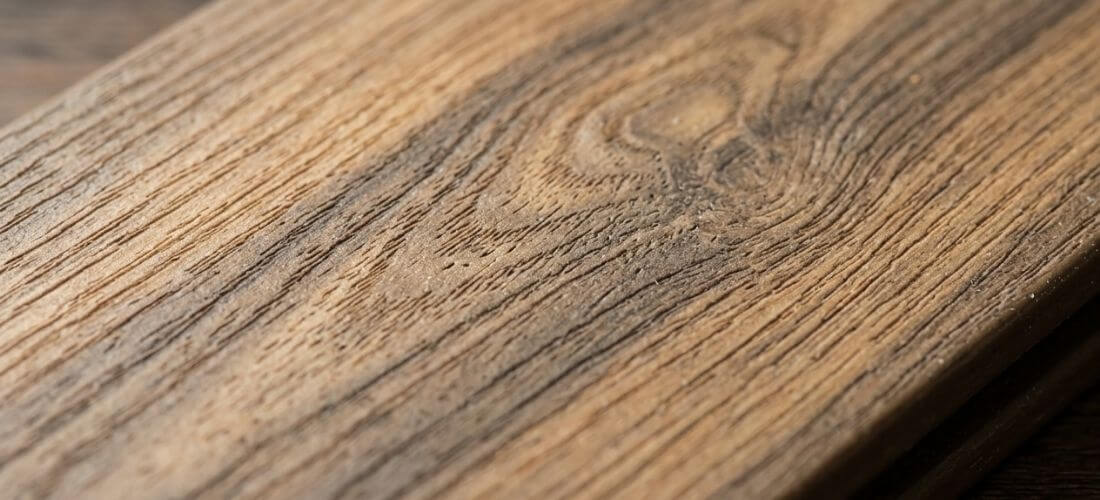 Detail WPC terasového prkna s věrnou strukturou dřeva — kresba letokruhů a barevné variace