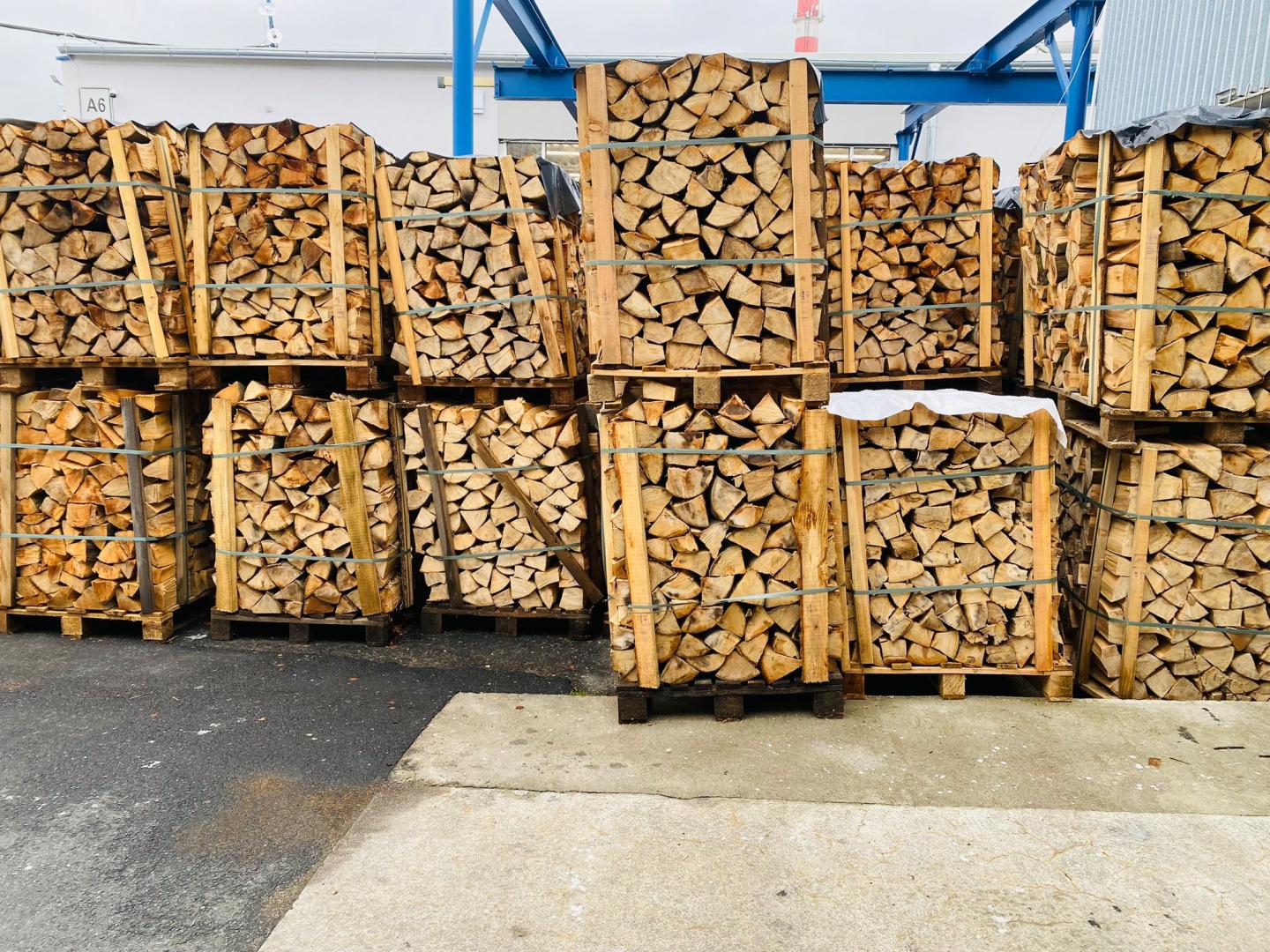 Štípané bukové palivové dřevo na paletách připravené k prodeji