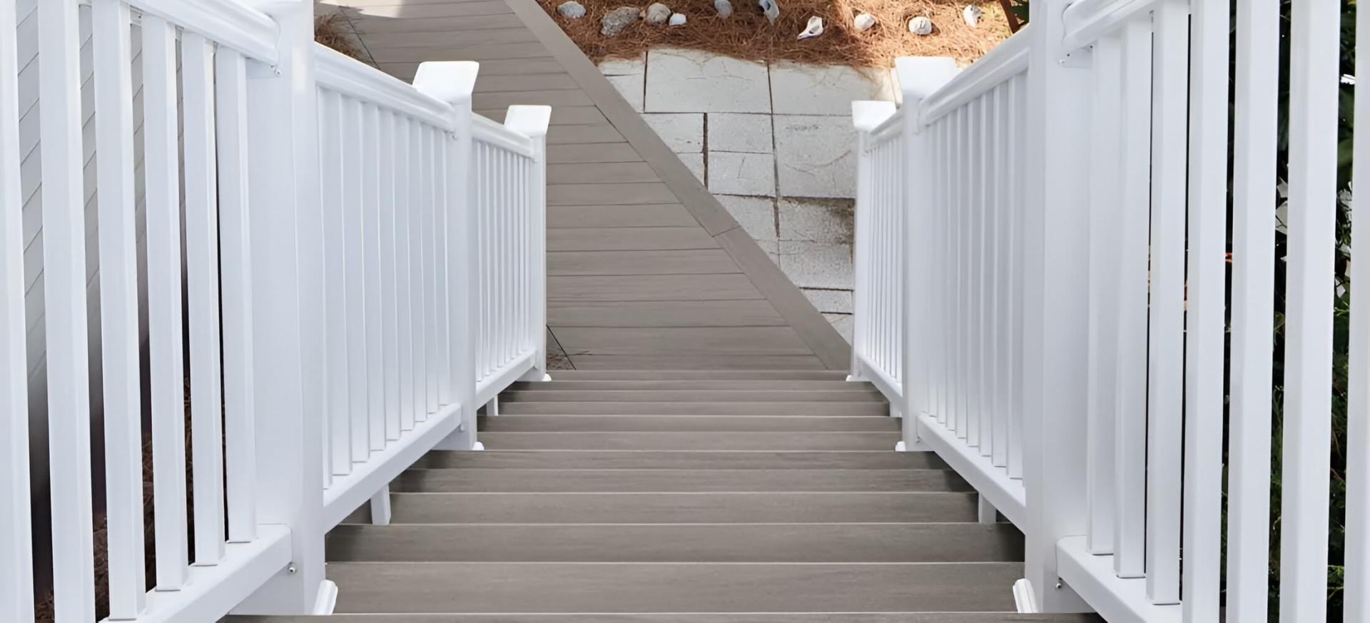 Schodiště z šedých PVC prken TimberTech Coastline s bílým zábradlím.